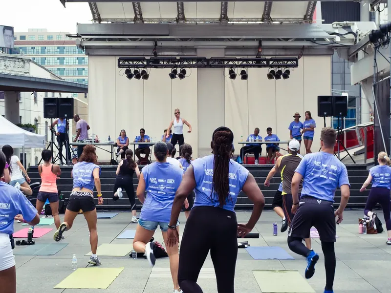 A group fitness session on mats at an outdoor event
