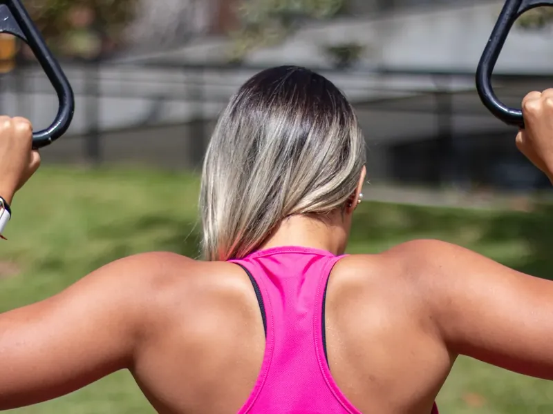 A woman training on gymnastic rings outdoors