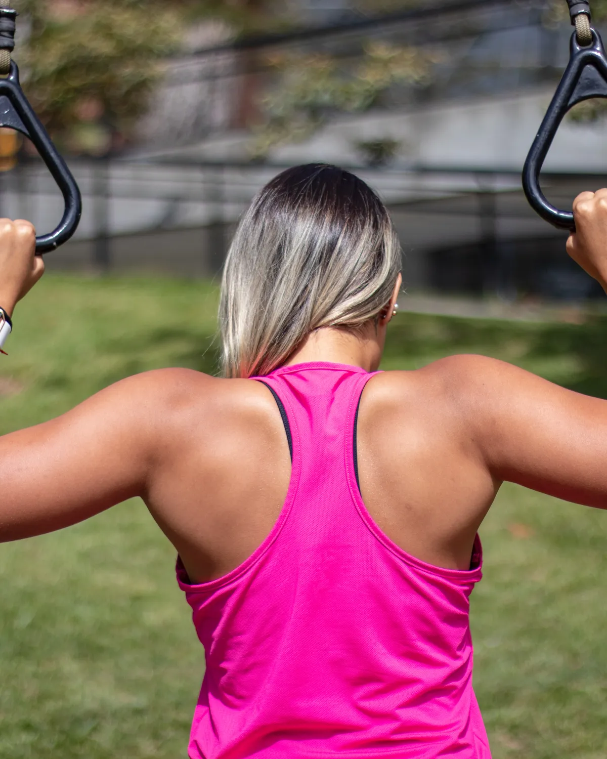 A woman training on gymnastic rings outdoors